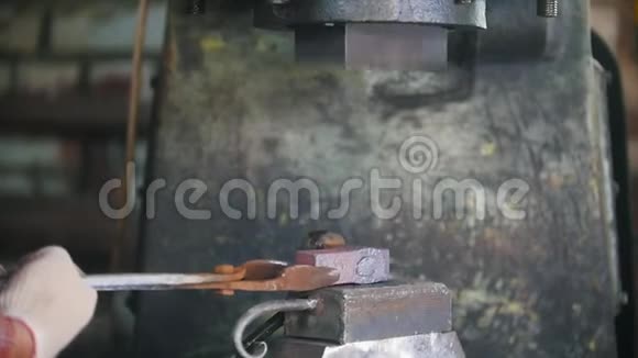 铁匠用电锤在铁砧上工作人用热钢打洞工艺视频的预览图