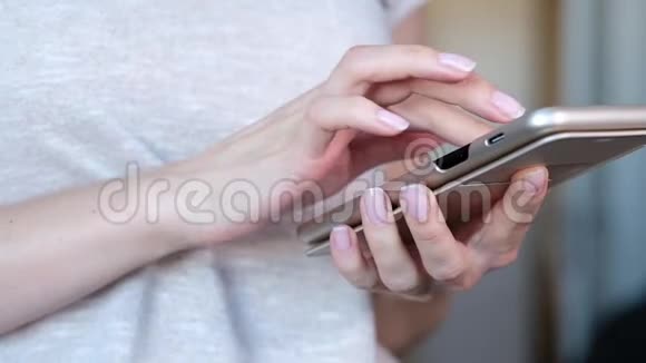 女人手里拿着现代手机触摸屏幕背景上模糊的办公室内部视频的预览图