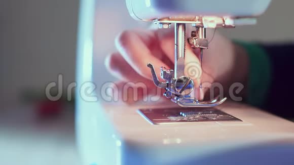 额外的特写缝纫针在机器上裁缝的手插入线视频的预览图