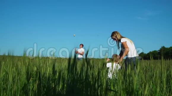 幸福的家庭母亲和儿子去田里找父亲父亲踢足球视频的预览图