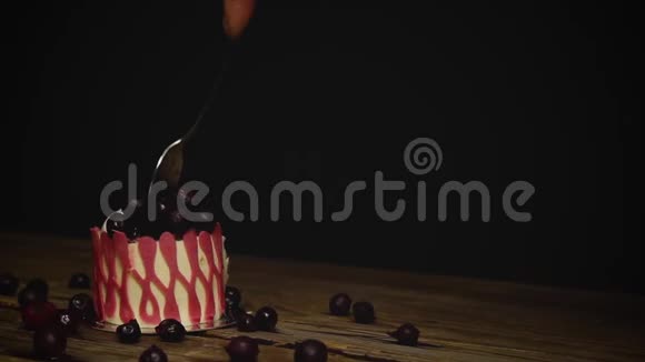 老式木桌上的节日粉红色蛋糕手咬掉一块长柄的勺子很长一段时间近点视频的预览图