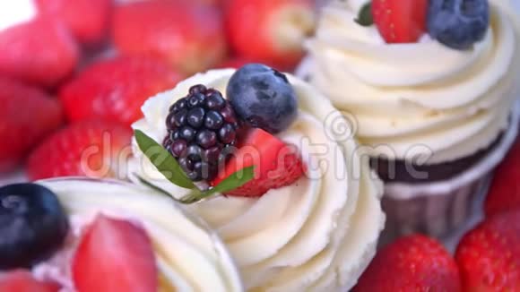 很少有美味的水果蛋糕有白色的鲜奶油和新鲜的红黑浆果片视频的预览图