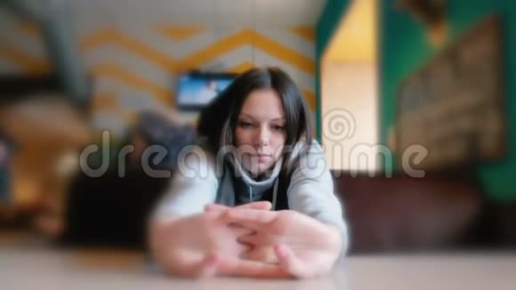 女人伸懒腰打哈欠悲伤的女人坐在咖啡馆里等待她的命令特写镜头视频的预览图
