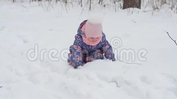 冬天和圣诞节的概念快乐的小女孩在冬天的公园里玩雪视频的预览图