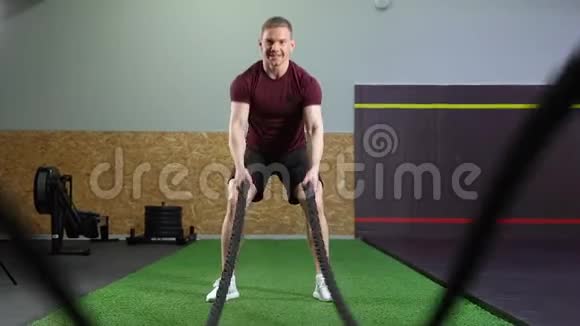 男子在健身房进行交叉健身训练时用绳子做运动视频的预览图