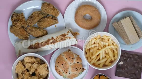 不健康的食品观念快餐汉堡甜甜圈粉底炸薯条手拿食物视频的预览图