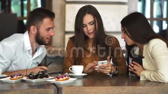 快乐的少女潮男在智能手机上播放女友视频时看镜头浪漫的情侣视频的预览图