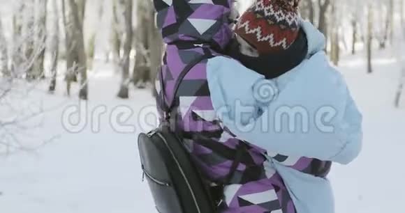 冬天一个带着一个小孩子的女人穿过公园视频的预览图