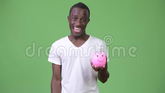 年轻的非洲男人拿着储蓄罐竖起大拇指视频的预览图