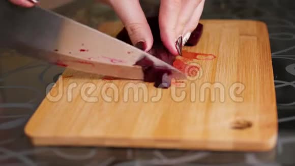 切煮甜菜女性的手在木切割板上用一把大刀切开的甜菜视频的预览图