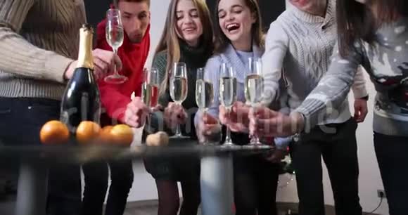 新年庆典男孩和女孩拿着圣诞树站在房间里的香槟着酒杯视频的预览图