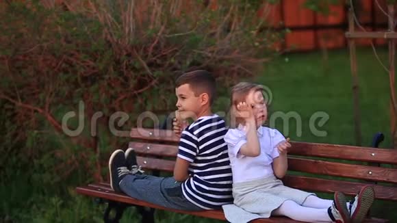 小男孩和小女孩坐在长凳上吃冰淇淋视频的预览图