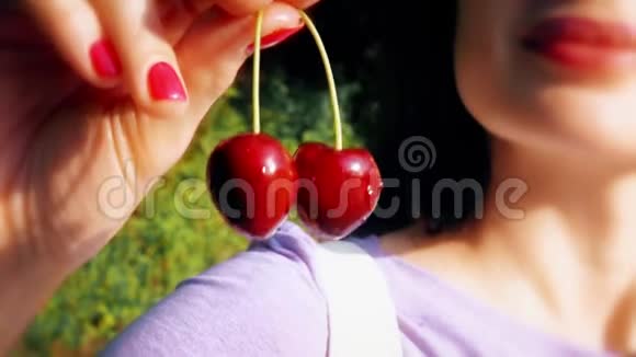 美丽的年轻女人吃甜樱桃特写镜头视频的预览图