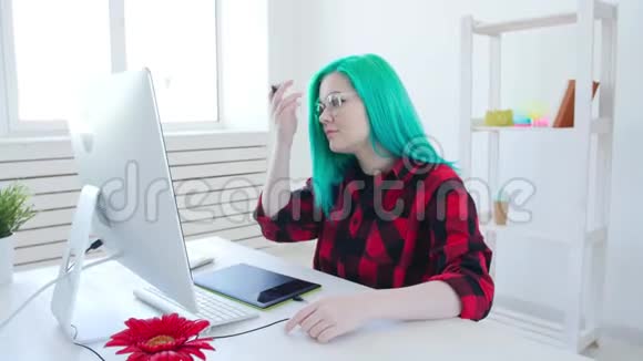 有彩色头发的年轻平面设计师使用平板电脑工作视频的预览图