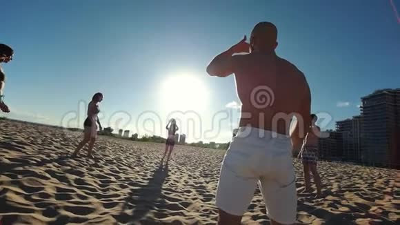穿着白色短裤的体育秃头在打沙滩排球时从女运动员那里拿球视频的预览图