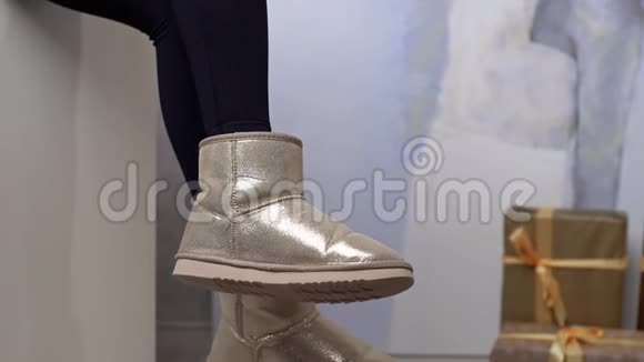 女人穿着冬鞋的腿女人摆动着脚穿着温暖的女人冬天的衣服视频的预览图