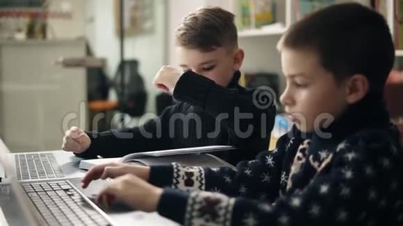 两个小男孩试图打字学习如何使用笔记本电脑的录像替代方案拟订教育视频的预览图
