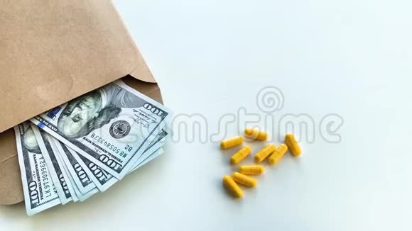 昂贵的药在白色桌子上放不同颜色的钞票视频的预览图