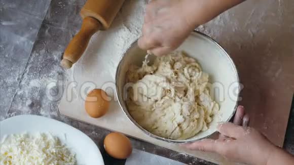 高级女性的特写双手正在家中的厨房里揉面团上面是视图视频的预览图