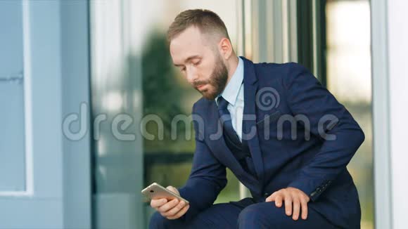 成功企业家坐在智能手机上的肖像视频的预览图