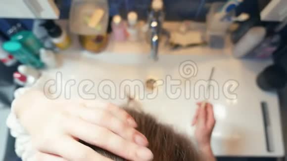 脱发秃顶金发女郎在浴室梳头水槽里还留着一簇头发复制空间视频的预览图