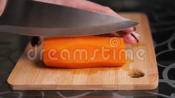 切煮胡萝卜女人的手正在用一把大刀在木切割板上切割煮好的胡萝卜视频的预览图