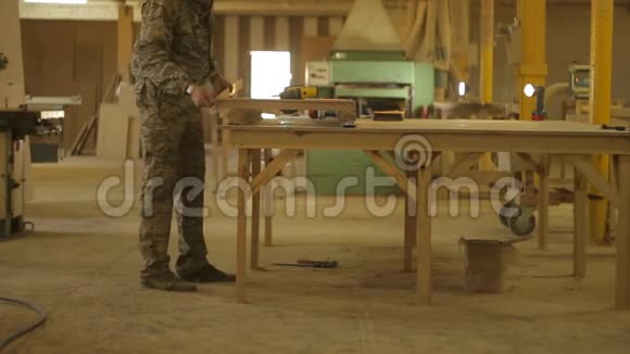 工人用螺丝刀在锯木机上组装完成的木制品组装加工视频的预览图