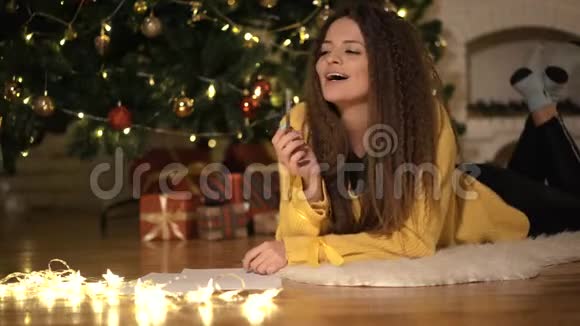 女孩在圣诞树的背景上给圣诞老人写了一封信视频的预览图