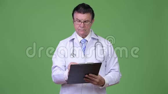 高级帅哥医生在写剪贴板时咨询视频的预览图