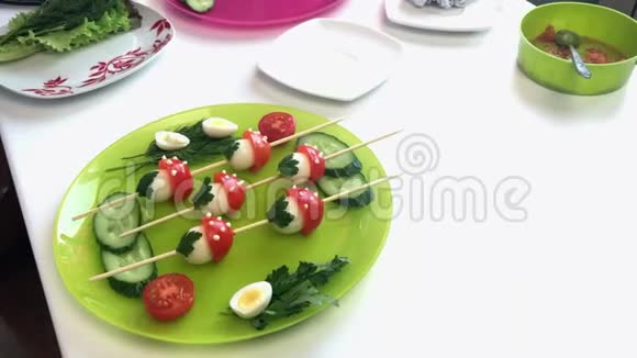 做饭的女人鹌鹑鸡蛋和西红柿的结巴串在木串上形状像蘑菇视频的预览图