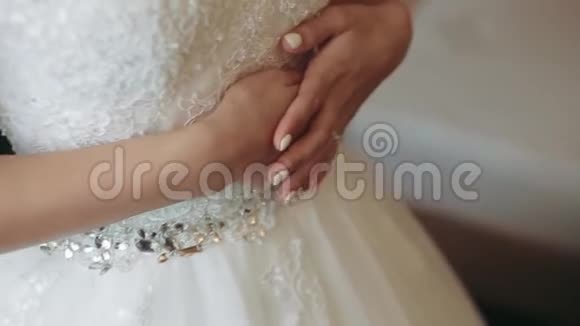 早安新娘伴娘在婚纱上系蝴蝶结女人双手在新娘的胸衣上系绸带帮助视频的预览图