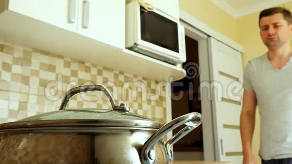 男人在厨房做饭用开水打开平底锅视频的预览图