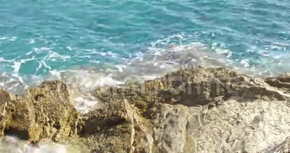 小浪在岩石海岸上翻滚视频的预览图