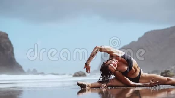这个女孩在海边从事伸展运动和体操视频的预览图