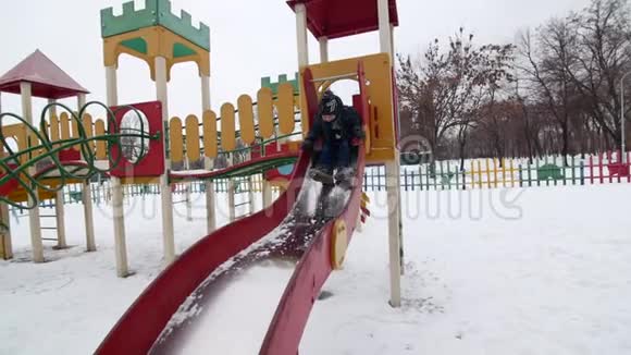 冬天的时候一个小男孩在操场上滑下来视频的预览图