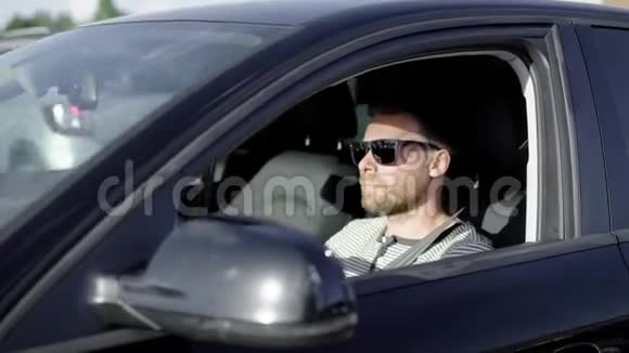 时尚的成功男人在夏天开一辆黑色豪华车视频的预览图