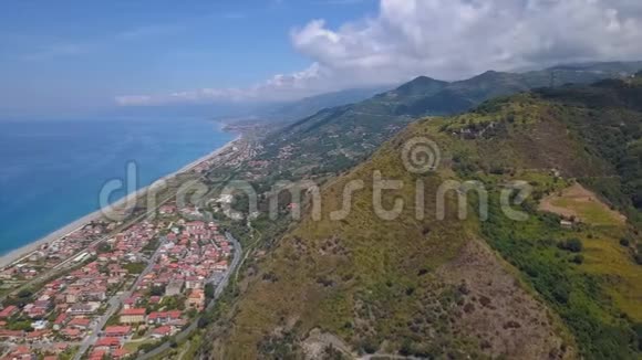 俯瞰海岸村庄和山脉的山景意大利卡拉布里亚的峡谷上空飞行晴天视频的预览图