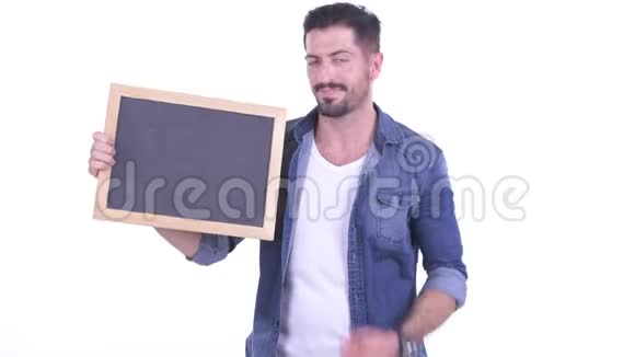 快乐的年轻留胡子的时髦男人拿着黑板竖起大拇指视频的预览图