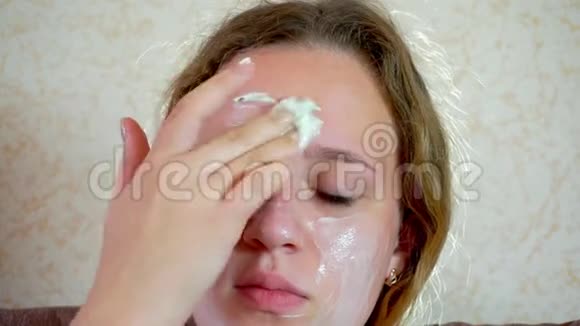 十几岁的女孩把一个清洁化妆品面具戴在脸上特写视频的预览图