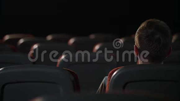 一个人坐在空荡荡的电影院里电影中人的后景视频的预览图
