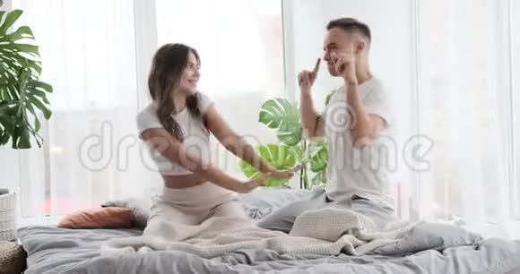 年轻夫妇在家里的床上跳舞视频的预览图