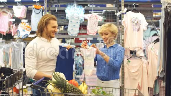 幸福夫妇在购物中心选择婴儿服装视频的预览图