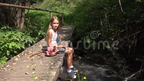 在河边玩水的孩子在山边露营的孩子在大自然中的女孩视频的预览图