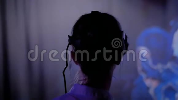 在黑暗互动展览中使用虚拟现实耳机的年轻女性视频的预览图
