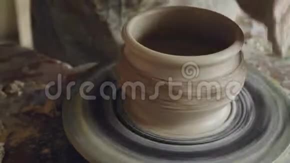 在旋转锅上用粘土加工的男性手的特写镜头投掷轮装饰壶装饰壶视频的预览图