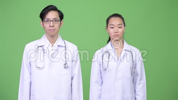 一对年轻的亚洲夫妇的医生一起竖起大拇指视频的预览图