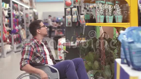 一个残疾的推销员坐在轮椅上把货物放在商店的货架上视频的预览图