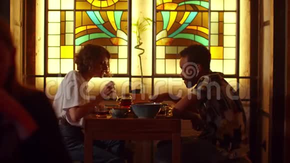 两个人坐在咖啡馆的桌子旁聊天吃东西视频的预览图