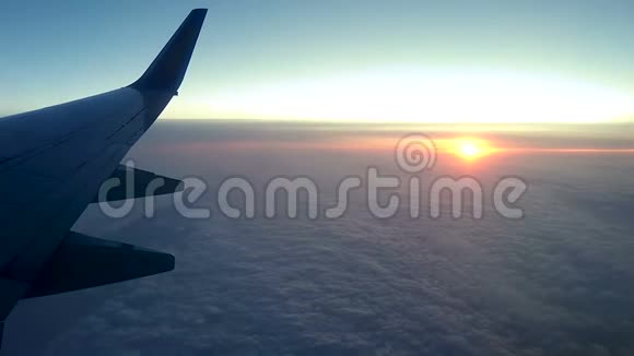 透过飞机的窗户在云层上日落视频的预览图