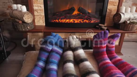 穿着羊毛短袜的脚在圣诞节时被温暖的炉火温暖视频的预览图